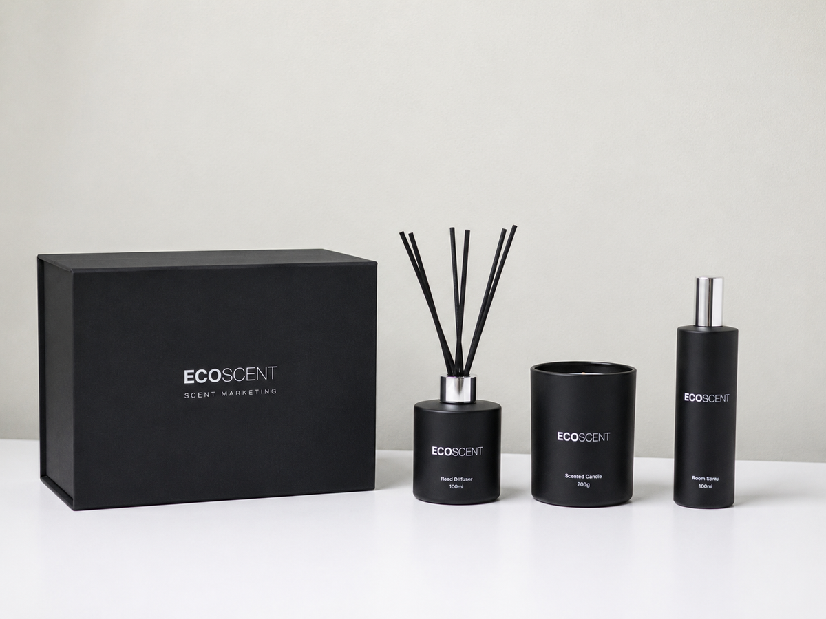 A three-piece ECOSCENT scent management set including a reed diffuser, a candle, and a perfume bottle, all in matte black with silver accents, displayed next to their black gift box on a white surface against a light gray background.