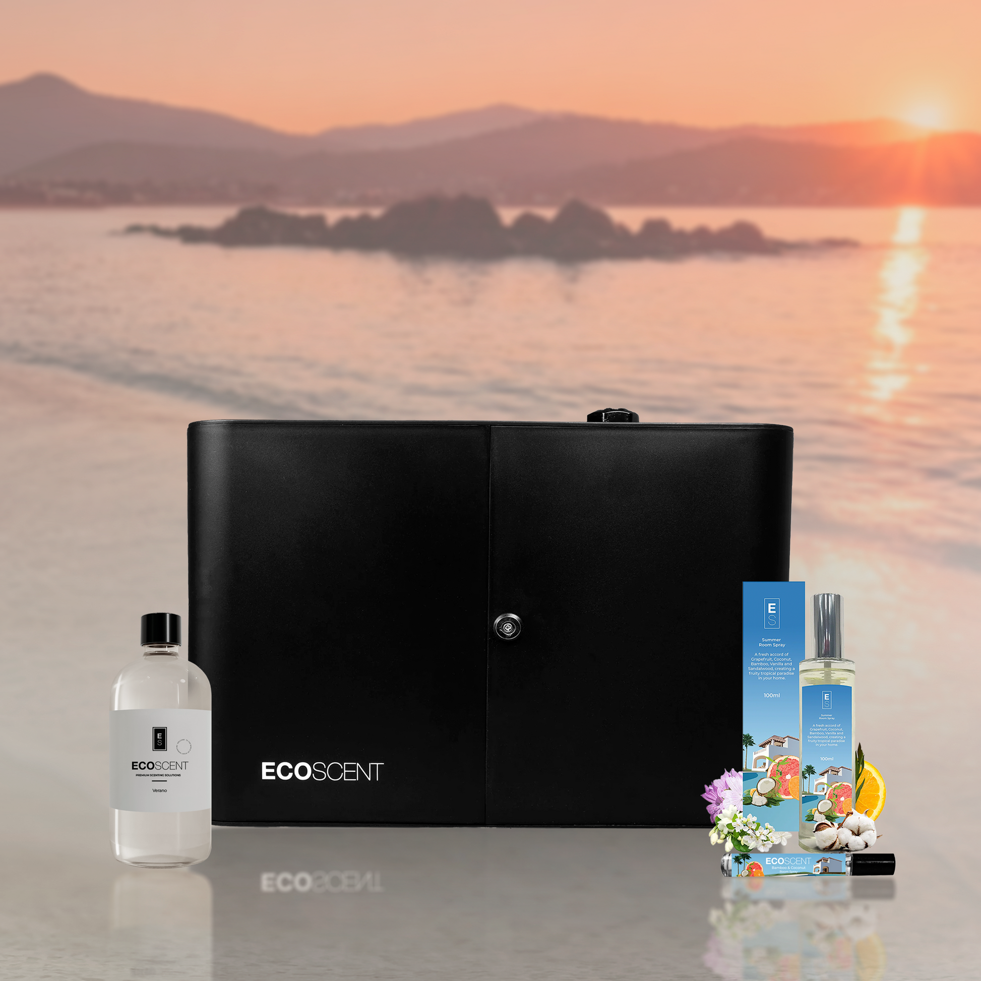 Black scent machine and bottles with 'EcoScent' branding on a beach at sunset.
