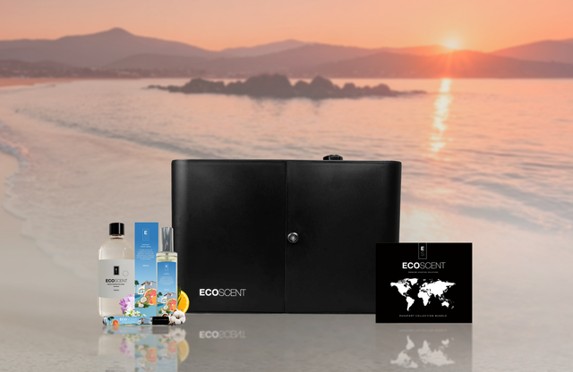 Black scent machine and bottles with 'EcoScent' branding on a beach at sunset.