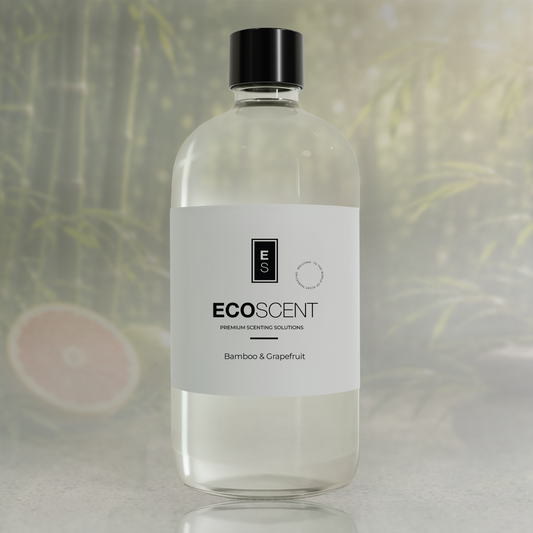 A clear plastic bottle of ECOSCENT Premium Scenting Solutions in the Bamboo & Grapefruit scent, featuring a white label and a black cap, set against a soft-focus background with green bamboo leaves.