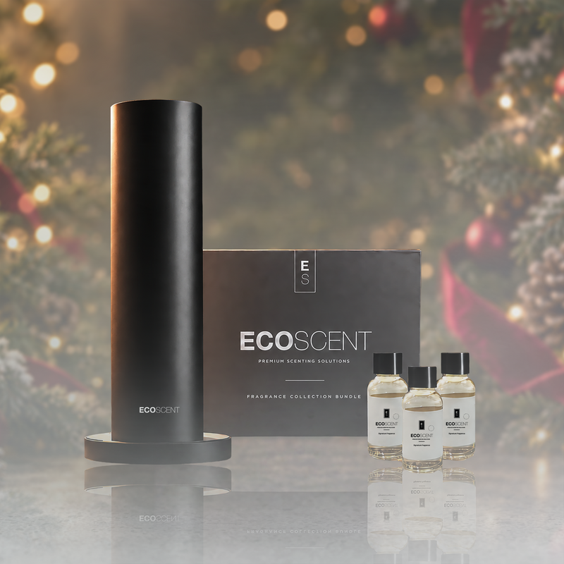 EcoScent The Scent of Christmas fragrance set with a black cylindrical diffuser, matching box, and three small clear bottles on a reflective surface.