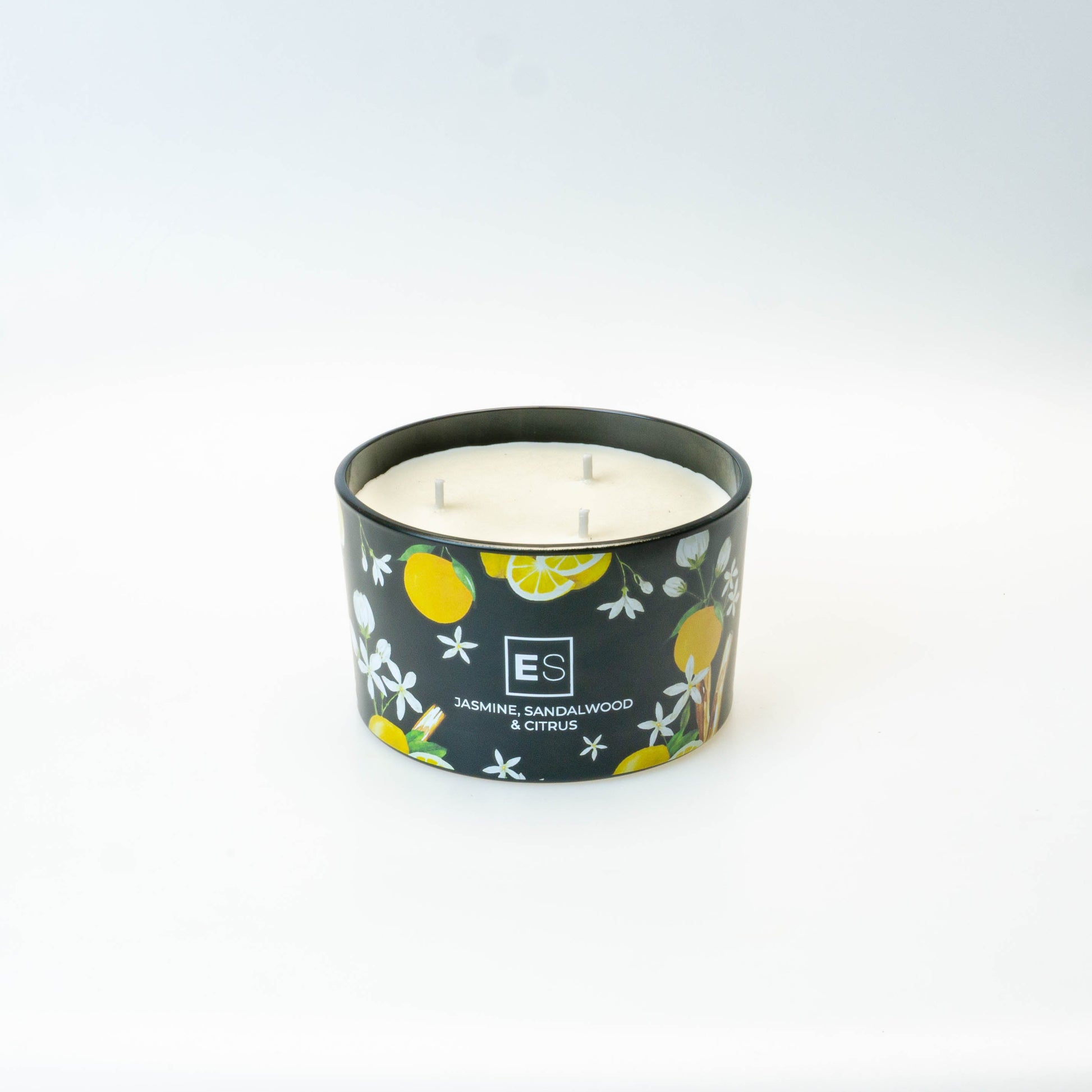 Candle in a decorative container on a white surface