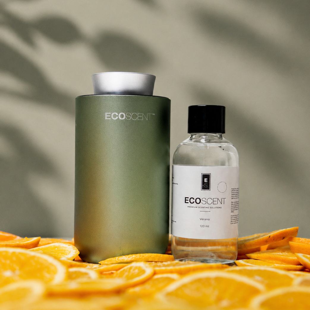 Two Ecoscent products on a surface with orange slices and a leafy background