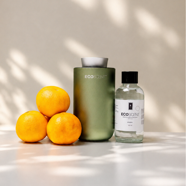 Two bottles of ecoxense products on a white surface with oranges and a neutral background