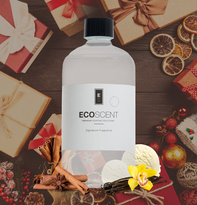 ecoscent-shop Cinnamon Fragrance Oil in a clear bottle with a black cap, featuring a minimal label design. The background shows festive gifts and decorative items like cinnamon sticks and dried citrus slices.