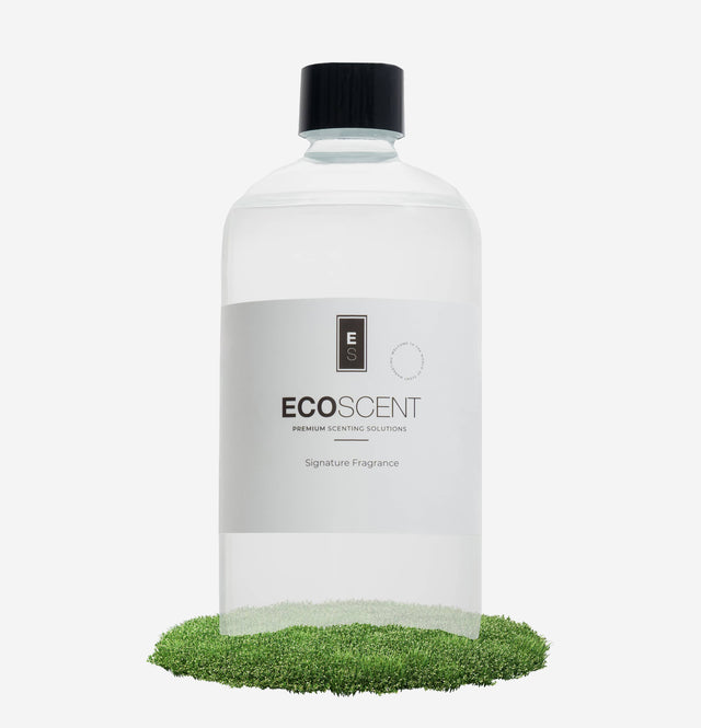 ecoscent-shop Fresh Cut Grass Fragrance Oil in a clear glass bottle, featuring a black screw cap, labeled with the brand name and description. The bottle is placed on a patch of artificial grass.