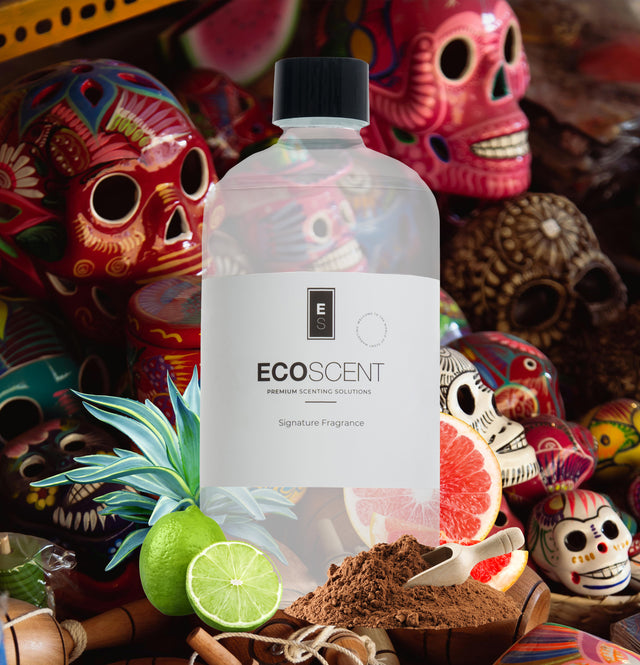 ecoscent-shop Mexican Chocolate Fragrance Oil with notes of cacao, citrus, and agave, presented in a clear bottle featuring a white label and black branding, set against a colorful backdrop with traditional skull decorations.