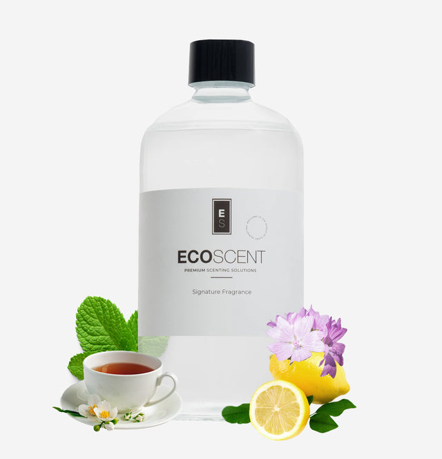 ecoscent-shop White Tea & Mint Fragrance Oil in a clear container, featuring a label with the brand name and description. The image is accompanied by mint leaves, a teacup, and lemon slices, showcasing the fragrance's ingredients.