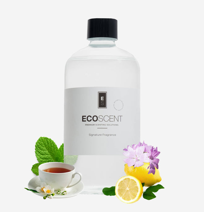 ecoscent-shop White Tea & Mint Fragrance Oil in a clear container, featuring a label with the brand name and description. The image is accompanied by mint leaves, a teacup, and lemon slices, showcasing the fragrance's ingredients.
