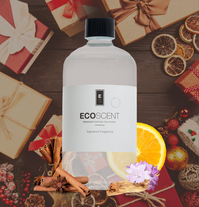 Ecoscent-shop Winter Season Fragrance Oil featuring citrus, cinnamon, and amber scents, packaged in a clear bottle with a black cap and labeled as Signature Fragrance. The background includes holiday-themed decorations.