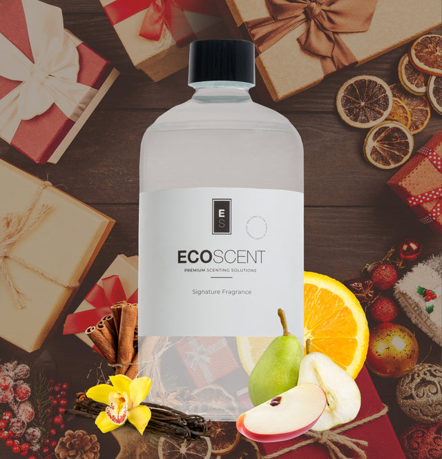 Ecoscent-shop Winter Wonderland Fragrance Oil in a clear bottle, featuring scents of apple, cinnamon, and vanilla, surrounded by festive decorations such as wrapped gifts and dried orange slices.