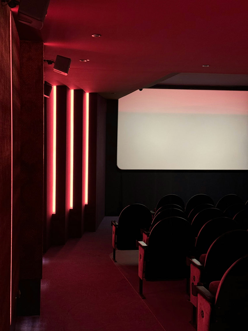 Luxury private cinema with red lighting and comfortable seating