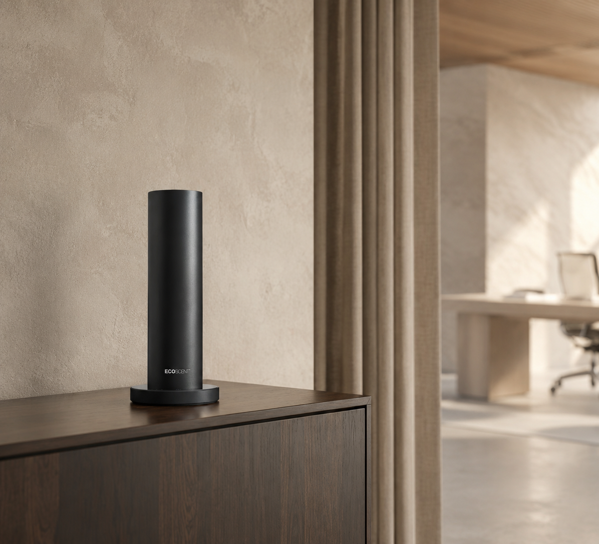 Black cylindrical scent machine on a wooden cabinet in a minimal office interior.