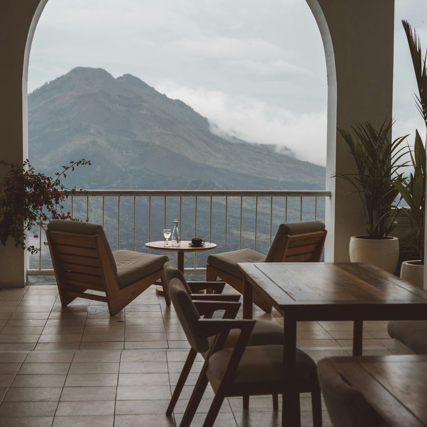 Indoor setting with wooden furniture and a large window view of mountains.