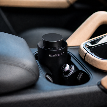 Black car scent machine in a cup holder with control dial, labelled ECOSCENT.